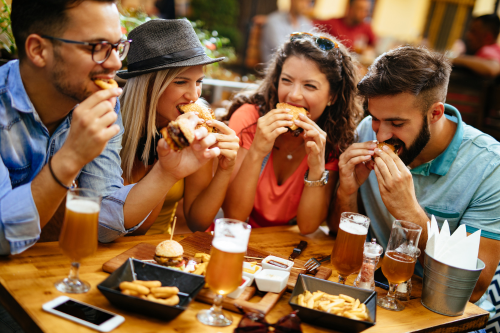 Eine Gruppe von Freunden genießt leckeres Essen und Getränke in einem gemütlichen Restaurant.